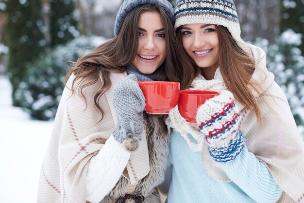 Jeunes amis avec boisson chaude en hiver