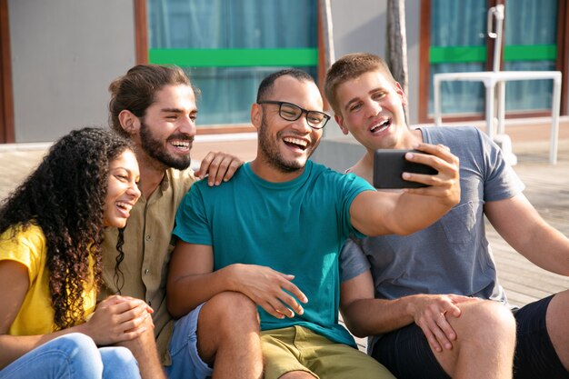 Jeunes amis joyeux pendant le chat vidéo