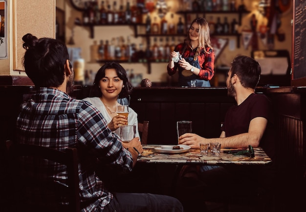 Photo gratuite jeunes amis multiraciaux se reposant dans le pub. fête des amis ensemble.