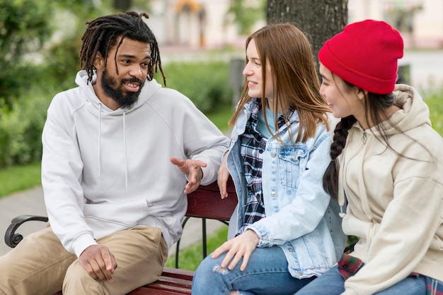 Photo gratuite jeunes amis en plein air sur banc