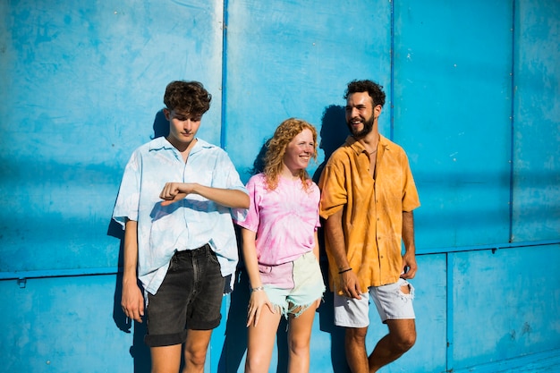 Jeunes amis posant avec un fond bleu