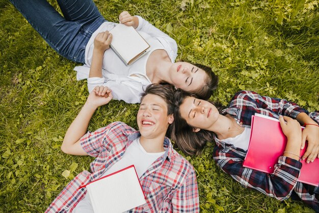 Jeunes amis posant sur l&#39;herbe