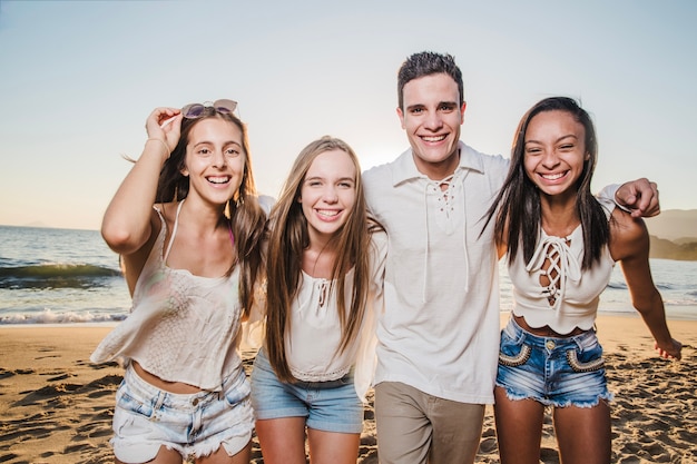 Jeunes amis posant sur la plage