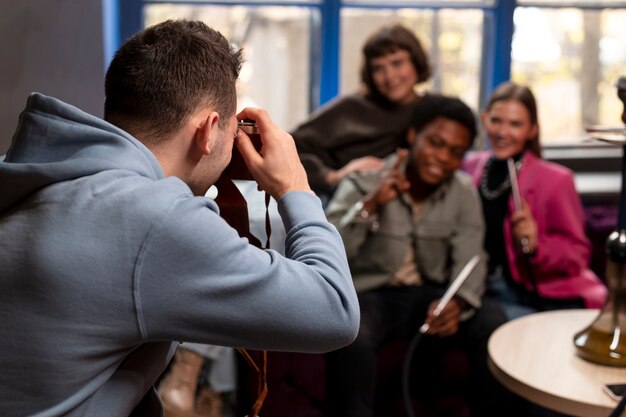 Jeunes amis posant pour une photo tout en profitant d'un narguilé