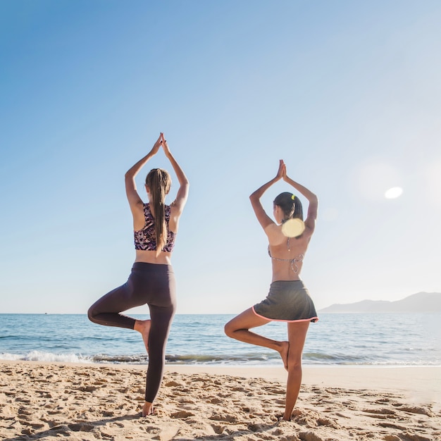 Photo gratuite jeunes amis pratiquant le yoga