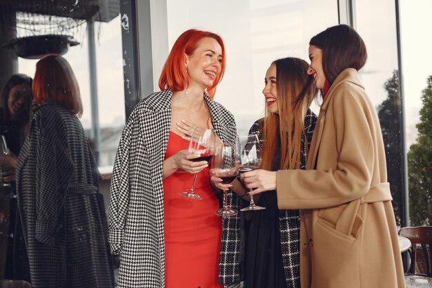 Les jeunes amis qui rient de boire du vin rosé à l'extérieur