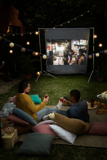 Photo gratuite jeunes amis s'amusant au cinéma en plein air