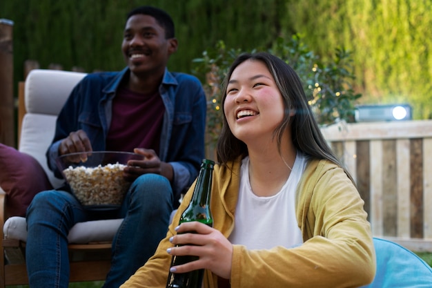 Jeunes amis s'amusant au cinéma en plein air