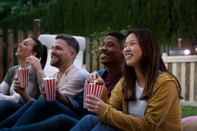 Photo gratuite jeunes amis s'amusant au cinéma en plein air