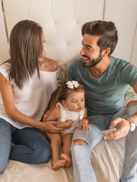 Jeunes avec bébé et smartphone se regardant