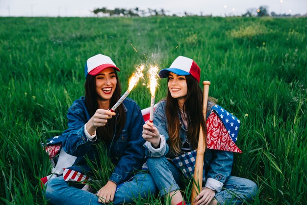 Jeunes belles dames célébrant le 4 juillet dans le champ