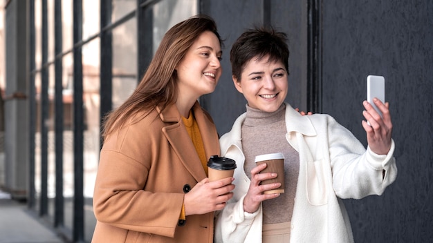 Photo gratuite jeunes belles femmes à l'aide de mobile