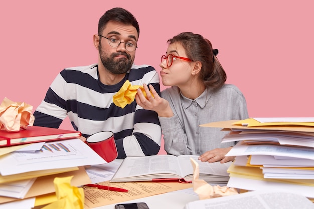 Jeunes collègues assis au bureau avec des documents