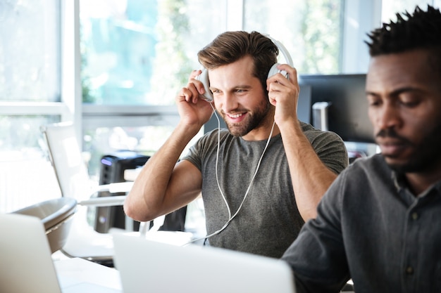 Jeunes collègues assis dans le coworking de bureau