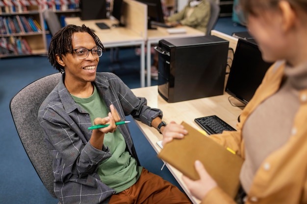 Jeunes collègues parlant dans la bibliothèque