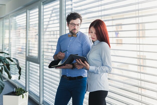 Jeunes collègues travaillant avec tablette et documents