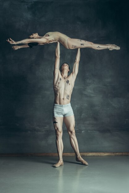 jeunes danseurs de ballet modernes posant sur gris