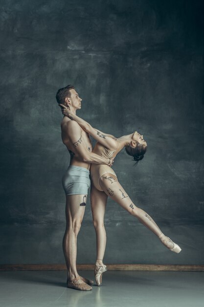 jeunes danseurs de ballet modernes posant sur gris