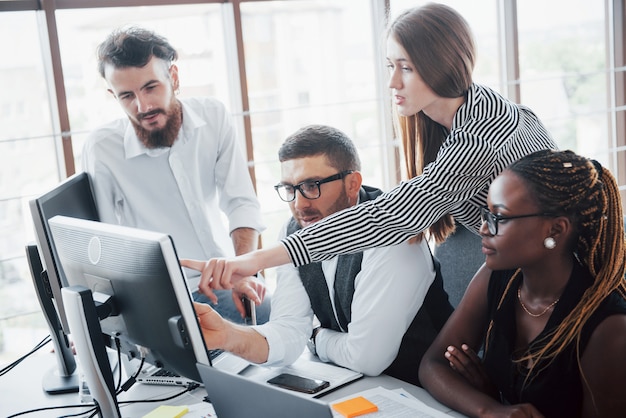 Photo gratuite les jeunes employés assis au bureau à la table et à l'aide d'un ordinateur portable