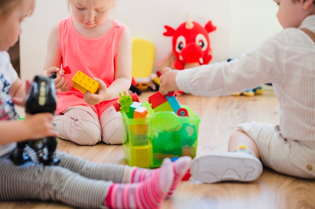 Jeunes enfants assis sur le sol jouant