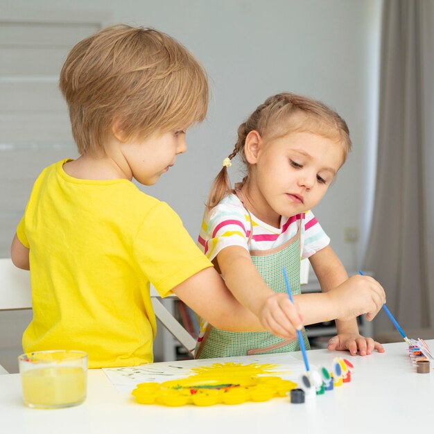 Jeunes enfants peignant à la maison