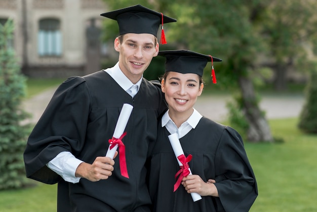 Photo gratuite jeunes étudiants fêtant leurs diplômes