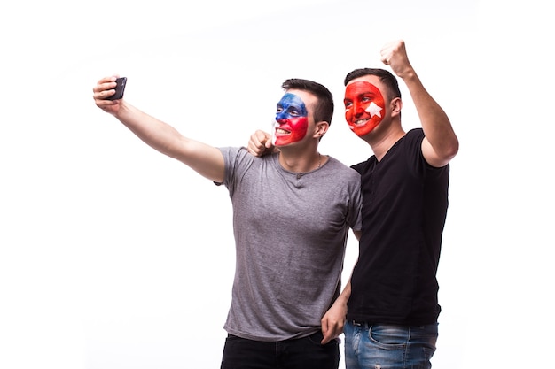 Les jeunes fans de football tchèque et tunisien prennent selfie isolé sur mur blanc