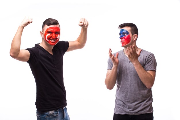 Les jeunes fans de football tchèques et tunisiens gagnent et perdent des émotions isolées sur un mur blanc