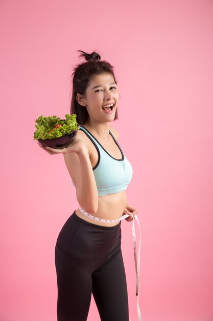 Les jeunes femmes aiment manger des légumes sur une rose.