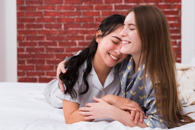 Jeunes femmes au lit embrassant