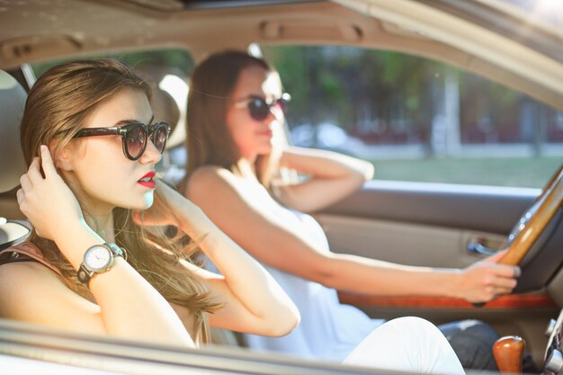 Les jeunes femmes dans la voiture en souriant