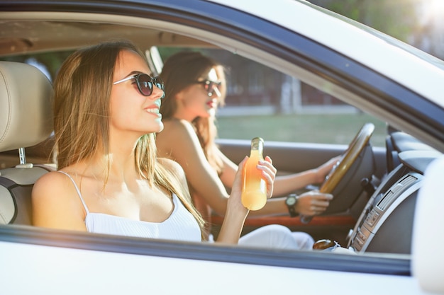 Les jeunes femmes dans la voiture en souriant