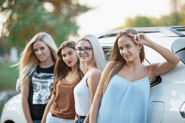 Les jeunes femmes debout près de la voiture