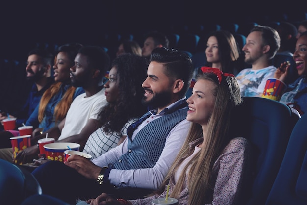 Photo gratuite jeunes femmes et hommes passant du temps libre au cinéma ensemble