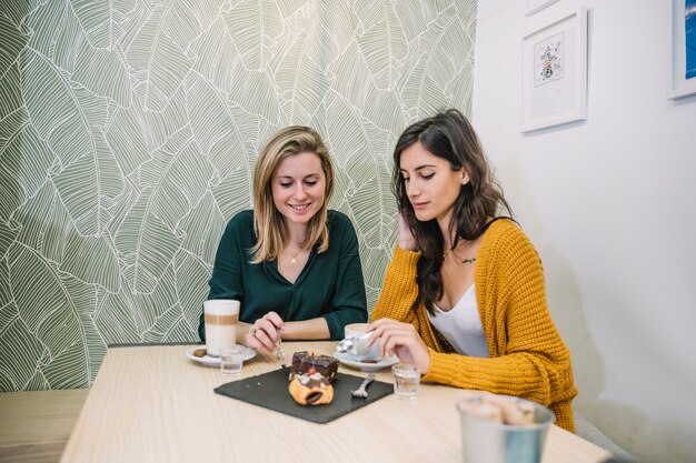 Jeunes femmes mangeant un gâteau au café