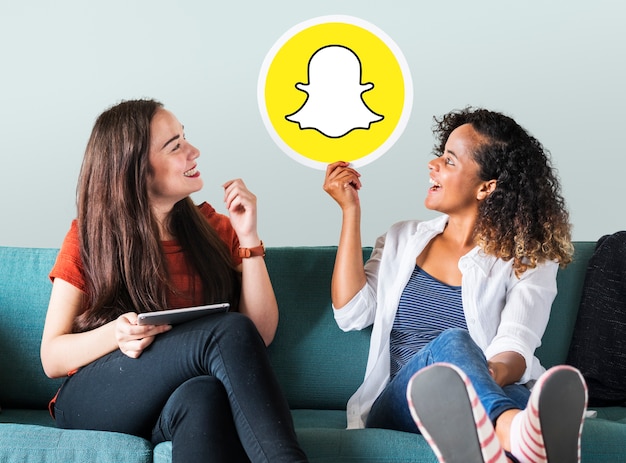 Photo gratuite jeunes femmes montrant une icône snapchat