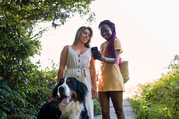 Jeunes femmes s'amusant avec un chien à la plage