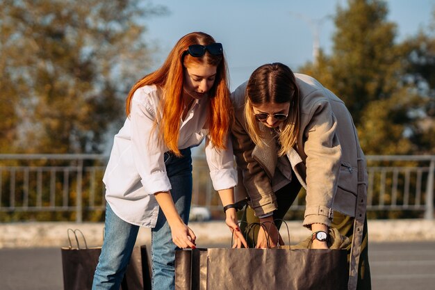 Jeunes femmes avec des sacs sur le parking