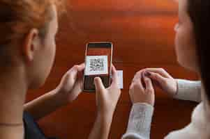 Photo gratuite jeunes femmes scannant le code qr