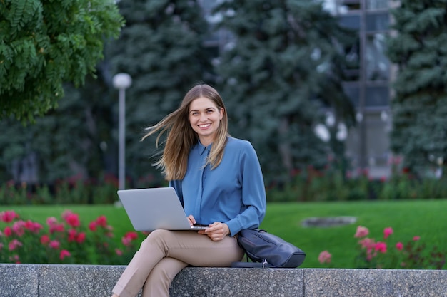 Jeunes femmes travaillant sur ordinateur portable sur la place de la ville