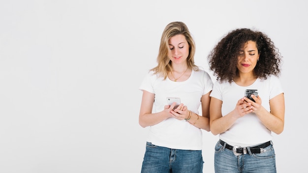 Jeunes femmes utilisant des smartphones ensemble