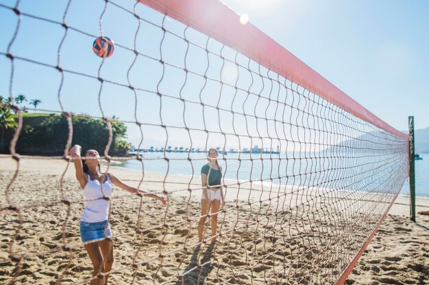 Jeunes filles jouant de la volée sur la plage