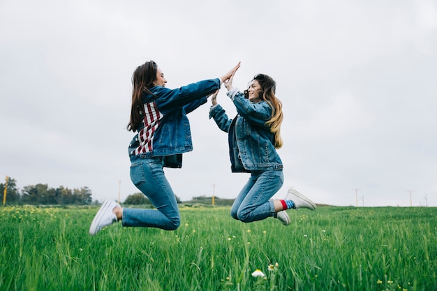 Jeunes filles s&#39;amuser dans le champ et applaudir