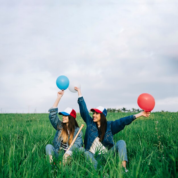 Jeunes filles s&#39;amuser dans le champ de l&#39;été avec des boules de différentes couleurs