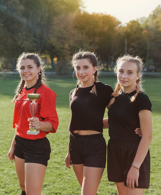 Photo gratuite jeunes filles sportives posant avec un trophée