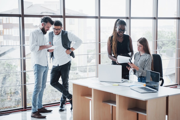 Les jeunes gens d'affaires discutent ensemble de nouvelles idées créatives lors d'une réunion au bureau.