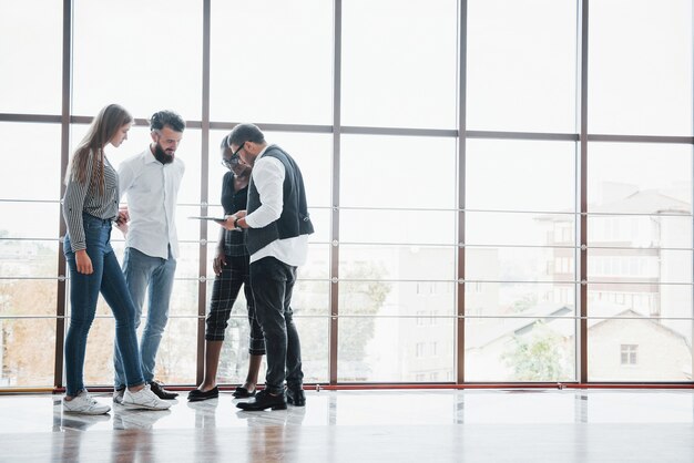 Les jeunes gens d'affaires discutent ensemble de nouvelles idées créatives lors d'une réunion au bureau.