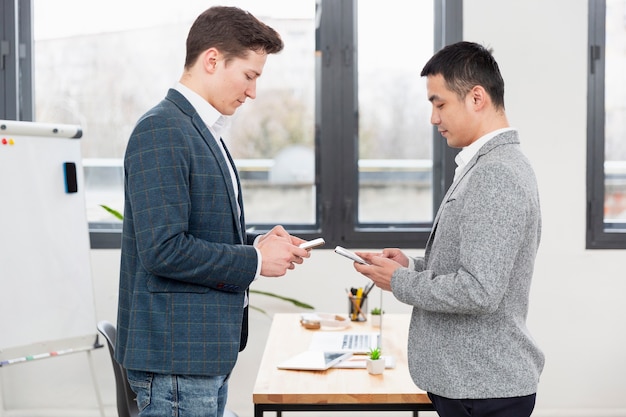 Jeunes hommes adultes travaillant ensemble au bureau