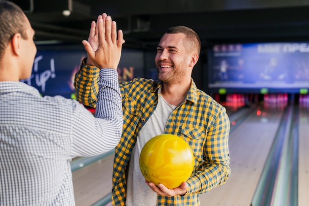 Photo gratuite jeunes hommes dans un club de bowling