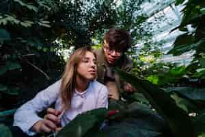 Photo gratuite de jeunes ingénieurs agronomes recherchent quelque chose en serre